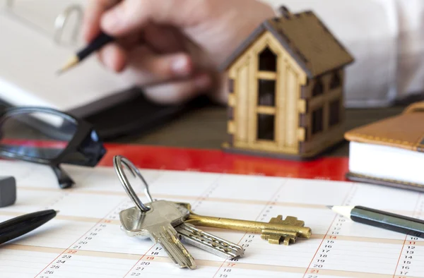 Keys on the table against the background of the little house Stock Photo