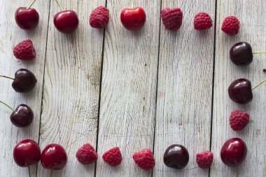 frame of raspberries and cherries