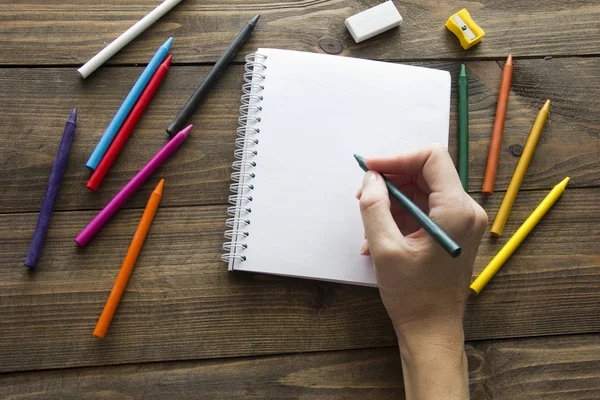 Colored pencils , notebook and  hand — Stock Photo, Image