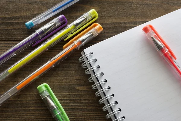 Multicolored ballpoint pens and notebook — Stock Photo, Image