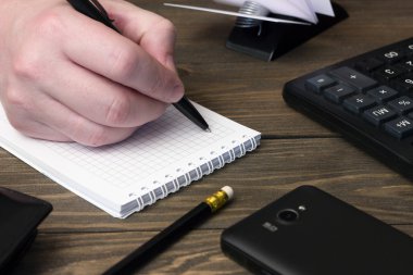 el yazısı bir not defteri, telefon ve hesap makinesi