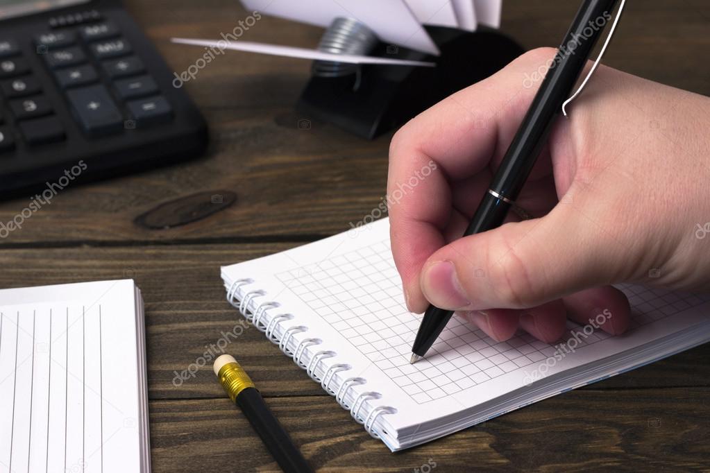 hand writes a ball pen  and a calculator
