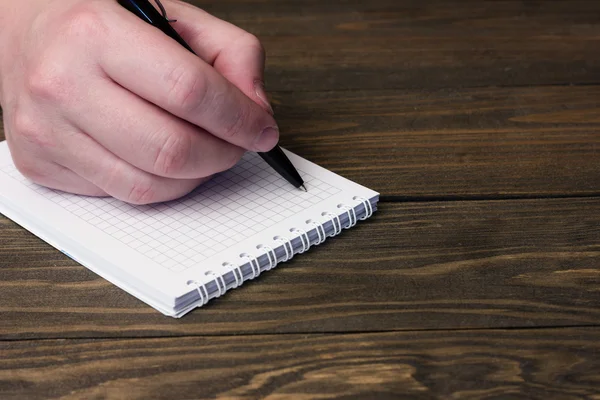 Hand and a notebook with a black ballpoint pen — Stock Photo, Image