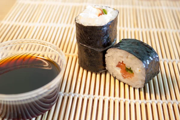 Sushi on bamboo mat with soy sauce — Stock Photo, Image