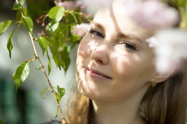 Vakker blond jente i blomsterhage – stockfoto