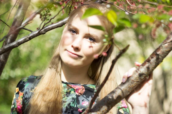 Krásná blonďatá dívka v kvetoucí zahradě, venku — Stock fotografie