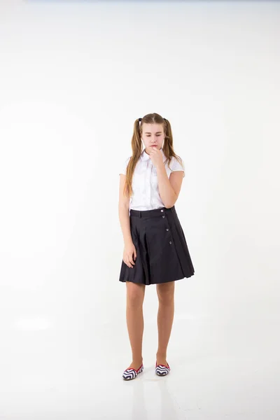 Schulmädchen mit Schwanz steht und denkt isoliert auf weißem Hintergrund — Stockfoto