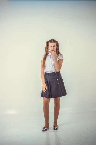 Schoolgirl with tails standing and thinking isolated on white background — Stock Photo, Image