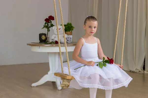 Portrait of little cute ballerina on swing with rose. Princess concept. Fairy tail — Stock Photo, Image