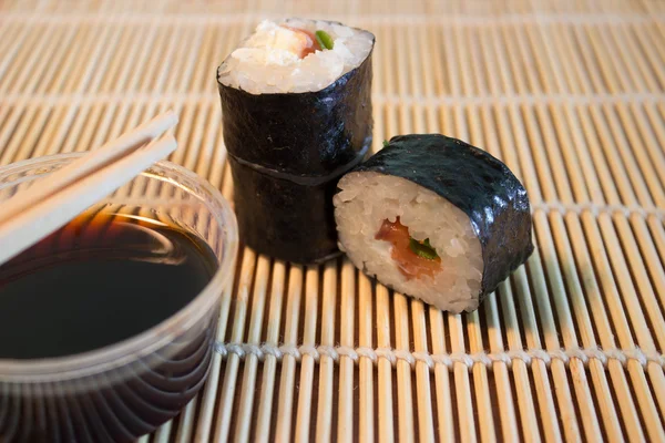 Sushi on bamboo mat with soy sauce — Stock Photo, Image