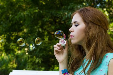 Güzel kadın kabarcıklar güneş açık havada üfleme