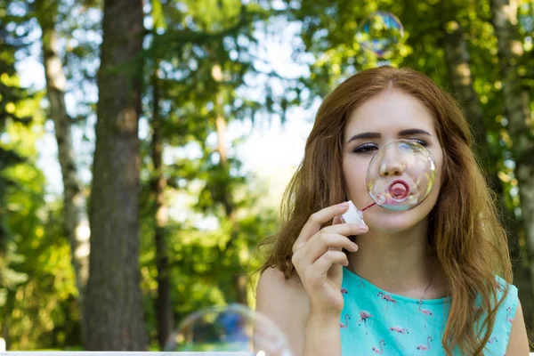 Krásná žena, foukání bublin v létě, slunečný den — Stock fotografie