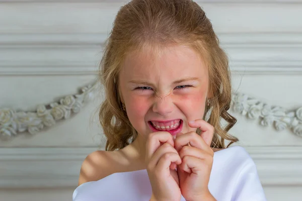 Evil emotion and smile, little beautiful angel in white robe — Stock Photo, Image