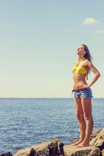 Vacker kvinna i bikini poserar nära havet — Stockfoto