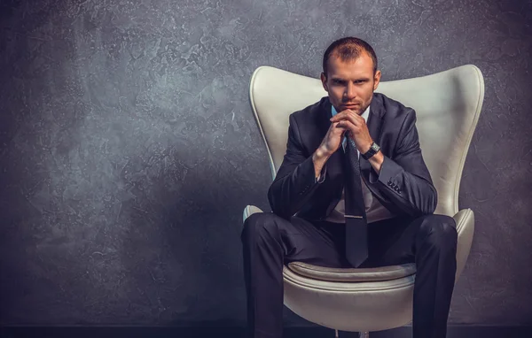Brutali uomini d'affari sexy in abito con cravatta seduta sulla sedia. Concetto di capo . — Foto Stock