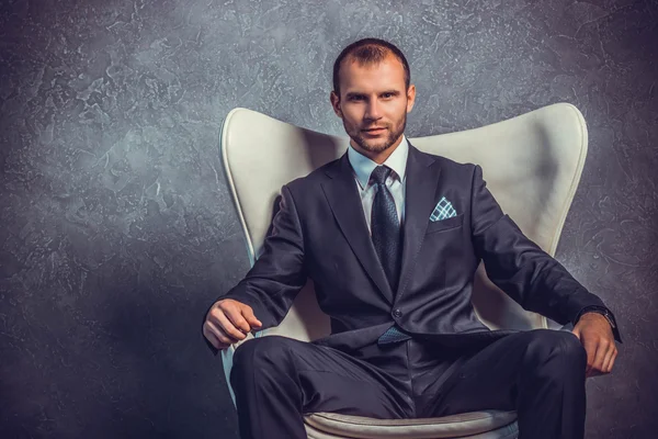Brutali uomini d'affari sexy in abito con cravatta seduta sulla sedia. Concetto di capo . — Foto Stock