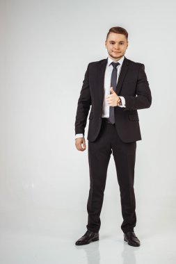 Başparmak gösterilen ayakta ve gülümseyen, siyah giyen adamlar iş uygun