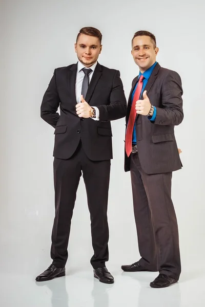 Due uomini d'affari in piedi come una squadra, pollice in su, isolati su sfondo bianco — Foto Stock