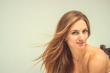 Beyaz elbiseli güzel seksi kızı izole sandalyede oturmak