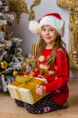 Noel şapka hediye ile gülümseyen küçük sevimli kız