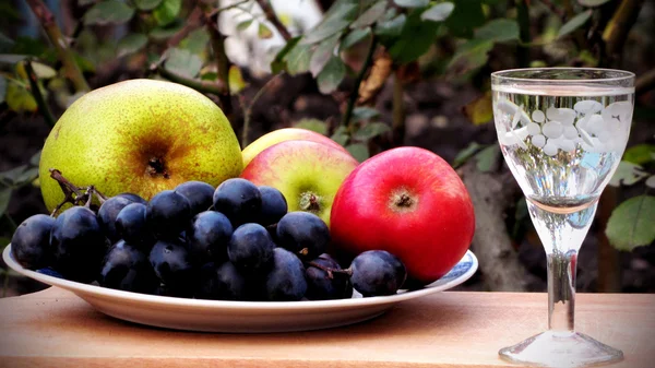 Bir bardak alkol arka plan üzerinde ile elma ve üzüm