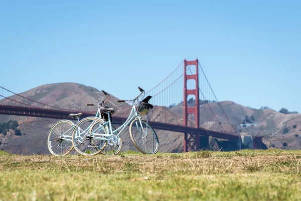 Dos bicicletas estacionadas en el césped frente al puente Golden Gate, San Francisco Fotos De Stock Sin Royalties Gratis