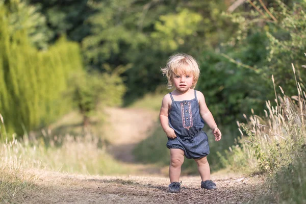 Mädchen läuft auf grünem Waldweg Stockbild