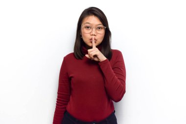 Sessiz ol. Genç, güzel Asyalı kadınların beyaz arka planda kırmızı gömlek giymesi hoş bir jest olur.