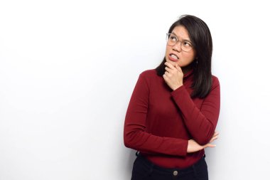 Genç ve güzel Asyalı kadınların beyaz arka planda izole edilmiş kırmızı tişört giydiğini düşünüyorum.