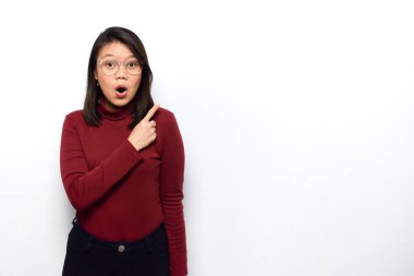 Noktalama Sağa ve beyaz arkaplanda izole edilmiş kırmızı gömlekli genç ve güzel Asyalı kadınların boş fotokopi alanını gösterme