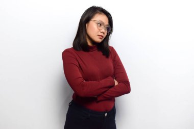 Genç Asyalı güzel kadınların çapraz kolları beyaz arka planda izole edilmiş kırmızı gömlek giyerler.