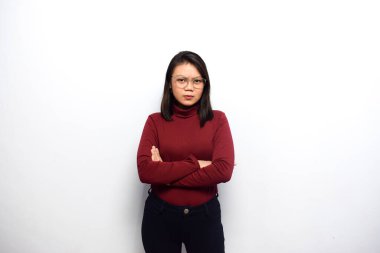 Çapraz kollar ve kızgın bakışlar. Genç Asyalı güzel kadınlar beyaz arka planda izole edilmiş kırmızı gömlek giyerler.