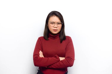 Çapraz kollar ve kızgın bakışlar. Genç Asyalı güzel kadınlar beyaz arka planda izole edilmiş kırmızı gömlek giyerler.