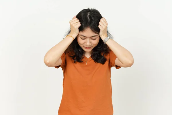 オレンジ色のTシャツを身に着けている美しいアジアの女性は白い背景に隔離された頭痛を持って — ストック写真