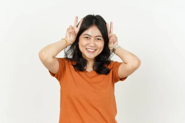 美丽的亚洲女人穿着橙色T恤 用手指做小兔子耳朵 与白色背景隔离 — 图库照片