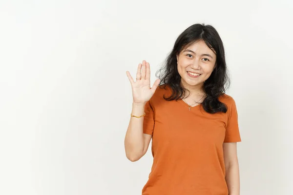 手を振って挨拶アジアの美しい女性のジェスチャー白い背景に隔離されたオレンジのTシャツを身に着けて — ストック写真