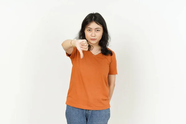 배경에 고립된 주황색 티셔츠를 아름다운 이시아 여성의 엄지손가락을 내리는 — 스톡 사진