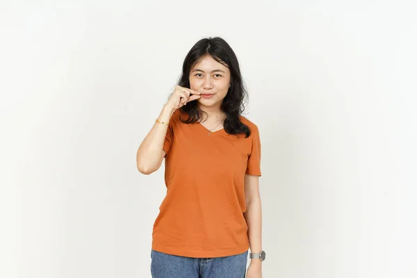 배경에 고립된 오렌지색 티셔츠를 아름다운 아시아 여성에게 입술을 유지하라 — 스톡 사진