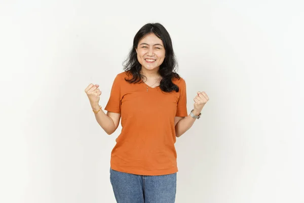 배경에 고립된 주황색 티셔츠를 아름다운 아시아 여성의 승리를 거둔다 — 스톡 사진