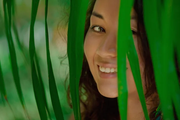 Портрет красивой азиатской девушки в зеленых листьях — стоковое фото