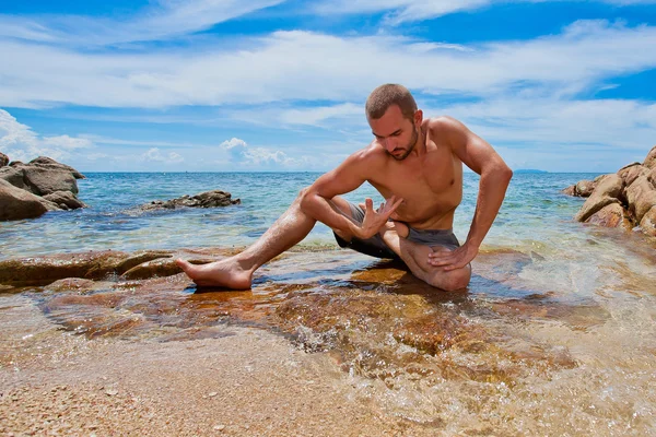 Člověk dělá jógu na pláži — Stock fotografie