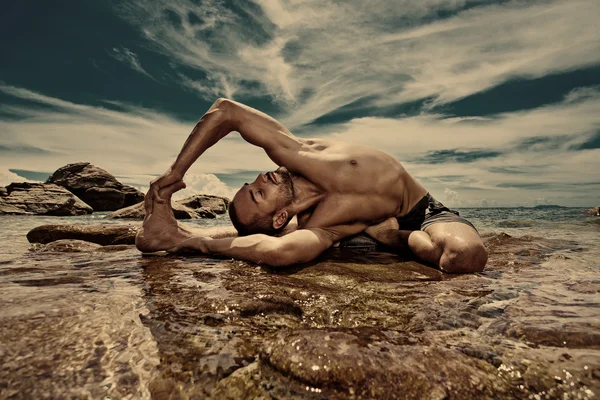 Uomo che fa yoga sulla spiaggia — Foto Stock