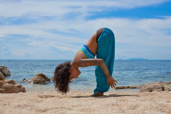 Schöne junge Frau macht Yoga am Strand — Stockfoto