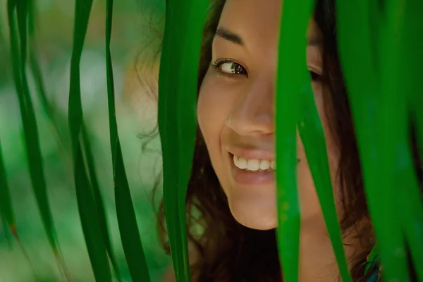 Portrait of beautiful asian girl in green leaves — Stock Photo, Image