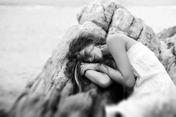 Bela jovem mulher dormir sobre as rochas na praia — Fotografia de Stock