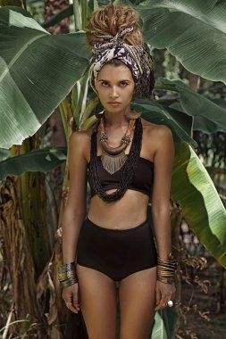 Attractive young boho woman in turban with jungle background clipart
