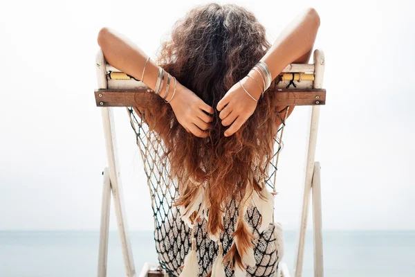 Attraente giovane donna che si rilassa sulla sedia a riva del mare. Giorno libero concetto — Foto Stock
