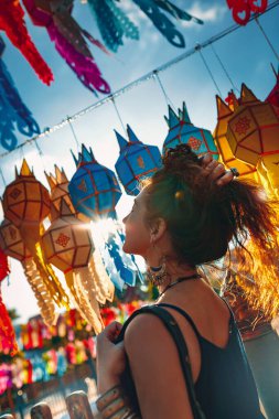 Budist tapınağında gün batımında renkli kağıt fenerlerde güzel genç kadın portresi.