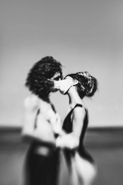 在海滩上 年轻夫妇通过口罩拥抱和亲吻 — 图库照片