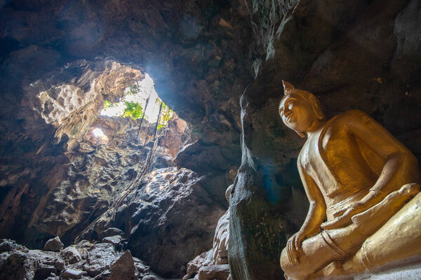 Ancient Buddha Image in Thum Khao Luang, the most popular cave of Buddhist place, where is the travel destination for tourism in Petchaburi, Thailand.